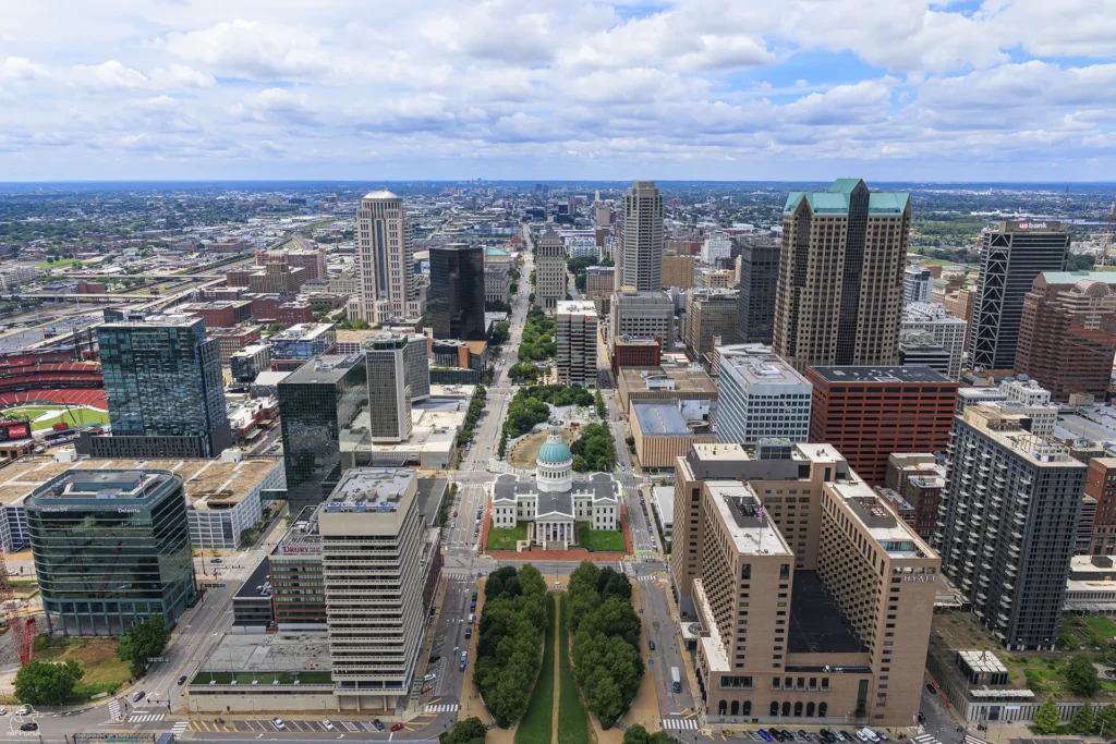 Blick vom Gateway Arch auf die grüne Kuppel des Old Courthouse und die Hochhäuser der Innenstadt von St. Louis.